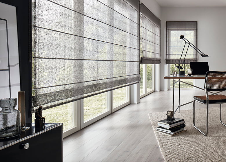 Arbeitszimmer mit großen Fenstern und Faltrollos