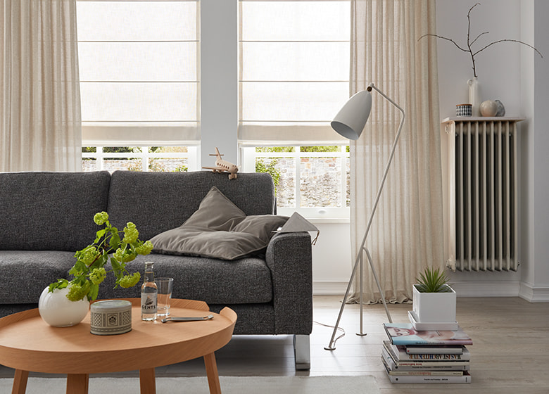 Faltrollo in beige im Wohnzimmer mit einem grauen Sofa