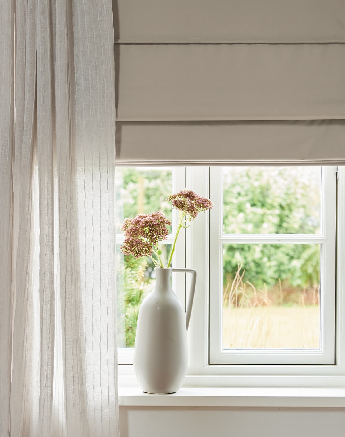 Eine Nahaufnahme von einem beigen Vorhang vor einem Fenster-